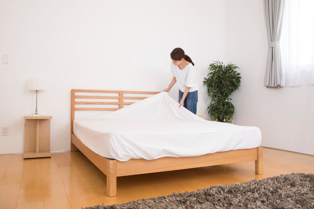 ボックスシーツを取り付ける女性
