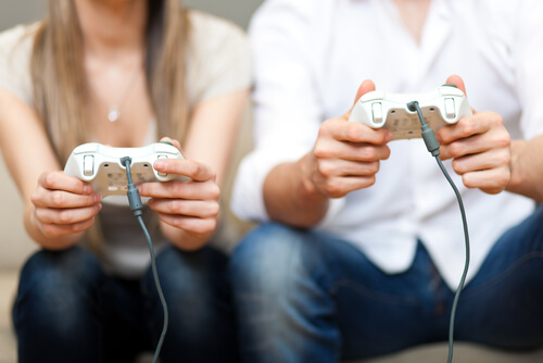コントローラーを持ってゲームをする男女