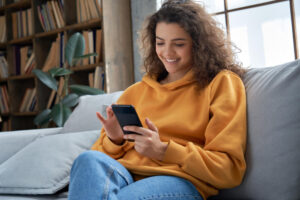 ソファでスマホを操作する女性