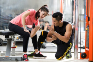 女性にトレーニングの指導をする男性